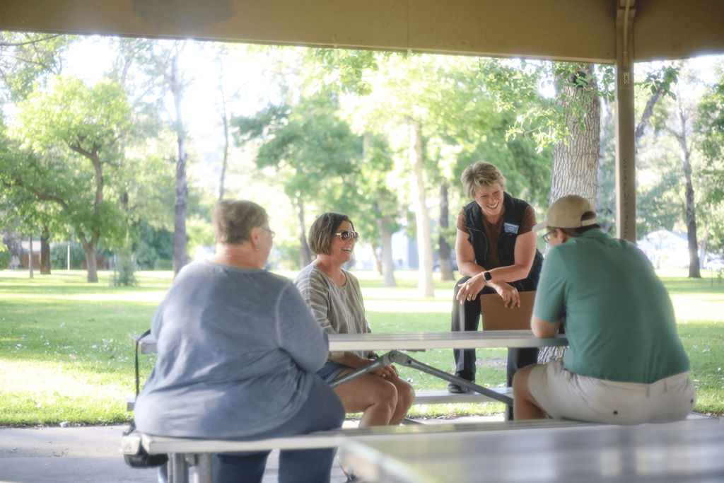 Denise Baum talks to community members in a park